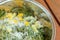 The fresh mint leaves with sugar and peaces of lemon in big metal bowl, on the wooden table. Preparing for mint confiture.