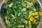 The fresh mint leaves with sugar and peaces of lemon in big metal bowl, on the wooden table. Preparing for mint confiture, jam.