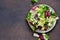 Fresh mix of salads: lettuce, arugula, spinach, mesclun, mache on a dark background. Top view