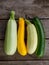 fresh mixed yellow, white, stripped and green zucchini on wooden background