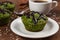 Fresh muffins with spinach, desiccated coconut, chocolate glaze and cup of coffee, delicious healthy dessert