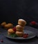 Fresh muffins tower with berries into plate on black background