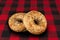 Fresh multi-grain bagel bread, isolated on a tartan red and black tablecloth