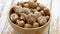 Fresh mushrooms in wooden bowl placed on white wooden table