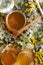 Fresh natual  honey in glass jar with wooden  honey spoon around herb flowers. flat lay