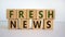 Fresh news time. Wooden blocks with words `fresh news`. Beautiful white background. Business and fresh news concept. Copy space
