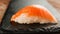 Fresh nigiri salmon sushi on black slate, close up