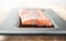 Fresh Norwegian salmon fillet on dark glass plate