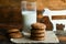 fresh oatmeal cookies and milk on wooden background with spikes of oats