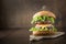 Fresh one beef burger with vegetables on wooden board. Close up. Party. Horizontal orientation. Space for text