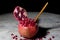 Fresh Open Pomegranate with Wooden Spoon on an Rustic Wooden Table, Black Background