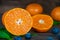 Fresh orange and blueberries on a brown wooden table with accompanying leaves. Front view