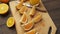 Fresh orange fruits on a wooden table, whole and sliced. A plate full of citrus slices.