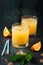 Fresh orange juice with crushed ice and fresh oranges and blue straws on an old vintage exotic background