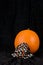 Fresh orange pumpkin on black velvet background, fabric pumpkin pattern face mask, celebrating Halloween