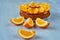 Fresh orange slice on the gray table close up. Sweet caramelized orange pie with fresh fruits on the blurred background