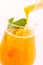 Fresh orange smoothie with mint leaf in glass isolated on white background, orange, mango, carrot or banana drink, product