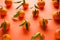 Fresh orange tangerines with leaves, on an orange background