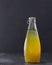 Fresh orange vegan beverage in bottle with cumquat and basil seeds for health on black bachground with copy space