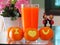 Fresh oranges carved symbol `I Love You` in front of Glass of orange juice and Wooden doll Couple