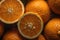 Fresh oranges on a dark background, some whole and some cut in half, covered in water droplets.