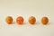 Fresh oranges and one basketball ball with eyes placed in line. Equality and respect. Minimal concept. Beige Background