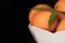 Fresh oranges in white porcelain Bowl. Healthy Citrus fruits Kitchen Concept on black background