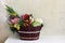 Fresh organic assorted vegetables and autumn garden flowers in handmade wicker basket. Farm still life composition