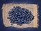 Fresh organic blueberries on burlap on a blue paper background.
