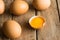 Fresh organic brown eggs scattered on wood table, open yolk, minimalistic, Easter