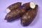 Fresh Organic Cassava Root, Manioc Esculenta, yuca On purple Background