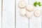 Fresh organic champignon mushrooms on white wood background. Cop