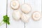 Fresh organic champignon mushrooms on wood background. Flat lay