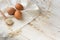 Fresh organic eggs,dry oatmeal flakes on wooden spoon scattered over white linen cloth,
