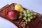 Fresh organic fruits on wood Serving tray. Assorted apple, pear and grapes.