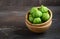 Fresh organic green tomatillos Physalis philadelphica with a husk on rustic wooden table.