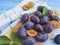 Fresh organic juicy dessert plum vitamin natural autumn delicious on a table , blue wooden background, towel