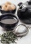 Fresh organic loose green tea with strainer infuser and black teapot and cane sugar on white background