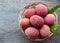 Fresh organic lychees in a basket on old wooden background.Exotic tropical lychee fruits.