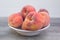 Fresh, organic peaches in white bowl, ,on wooden table