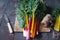 Fresh organic rainbow swiss chard leaves on dark wooden table, selective focus