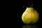 Fresh, organic, ripe, Green Anjou pear with the stem, water drops and reflection on a black background