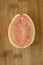 Fresh organic ripe red guavas fruit cut in half on a wooden board. Exotic fruits, healthy eating concept