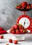 Fresh organic strawberries in an enamel plate and vintage red scales on background ready for cooking.