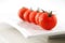 Fresh organic tomatoes on a white ceramic plate