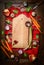 Fresh organic vegetables around old cutting board with wooden spoon on rustic napkin and wooden background. Top view, frame.