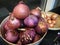 Fresh organic white onion bulbs and red shallot among many onion and shallot background in basket in supermarket