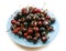 Fresh Overripe ripe Cherries on Blue Rustic Plate Top View