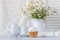 Fresh Oxeye Daisies on table in white Pitcher in interior