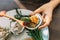 Fresh Oyster in shell in hand that topping with fried shallot, chili paste, Acacia Pennata and Thai style seafood sauce